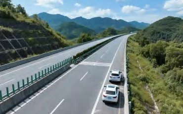 Luftaufnahme einer Autobahn durch bergiges Gelände mit fahrenden Fahrzeugen