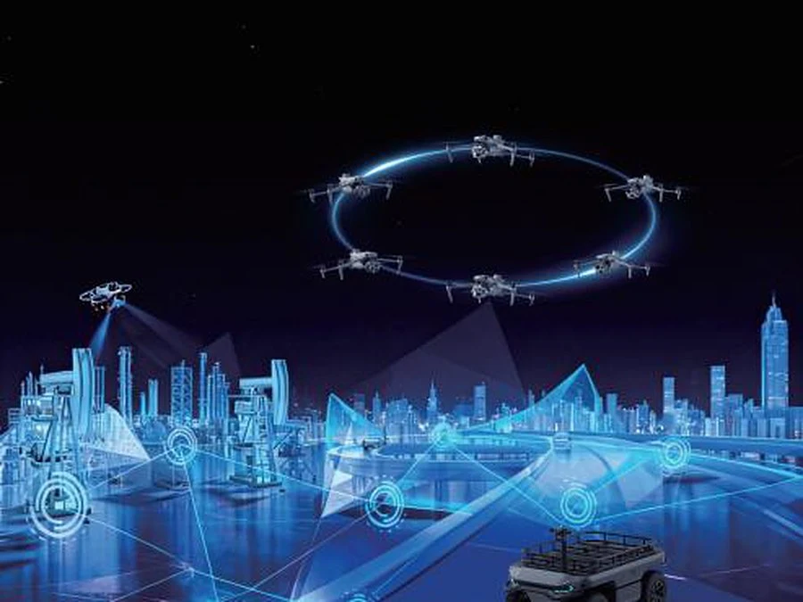 Visualisierung eines vernetzten Drohnenverbunds über einer Stadt mit angebundenem Bodenfahrzeug
